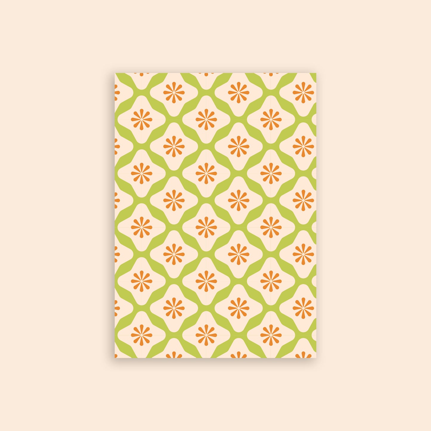 Green and orange diamond floral craft paper in front of a beige background.