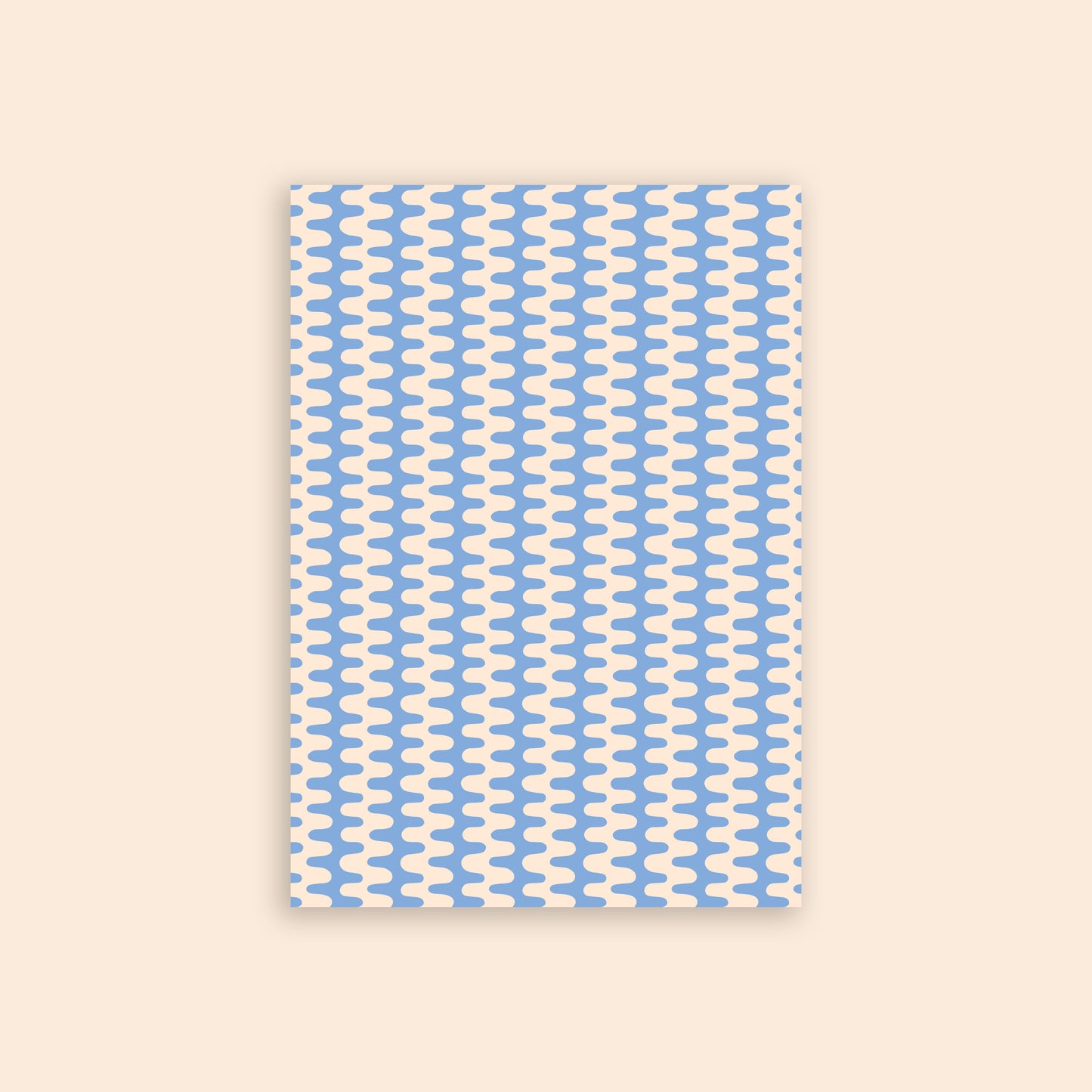 Blue and white geometric wiggle craft paper in front of a beige background.
