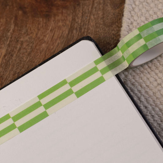A green brick checkerboard patterned washi tape stuck in a notepad.