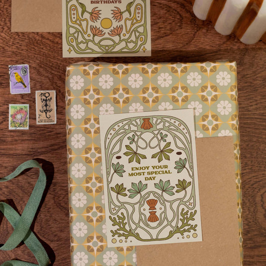 Decorative card with floral design and text sat on a gift on a wooden surface