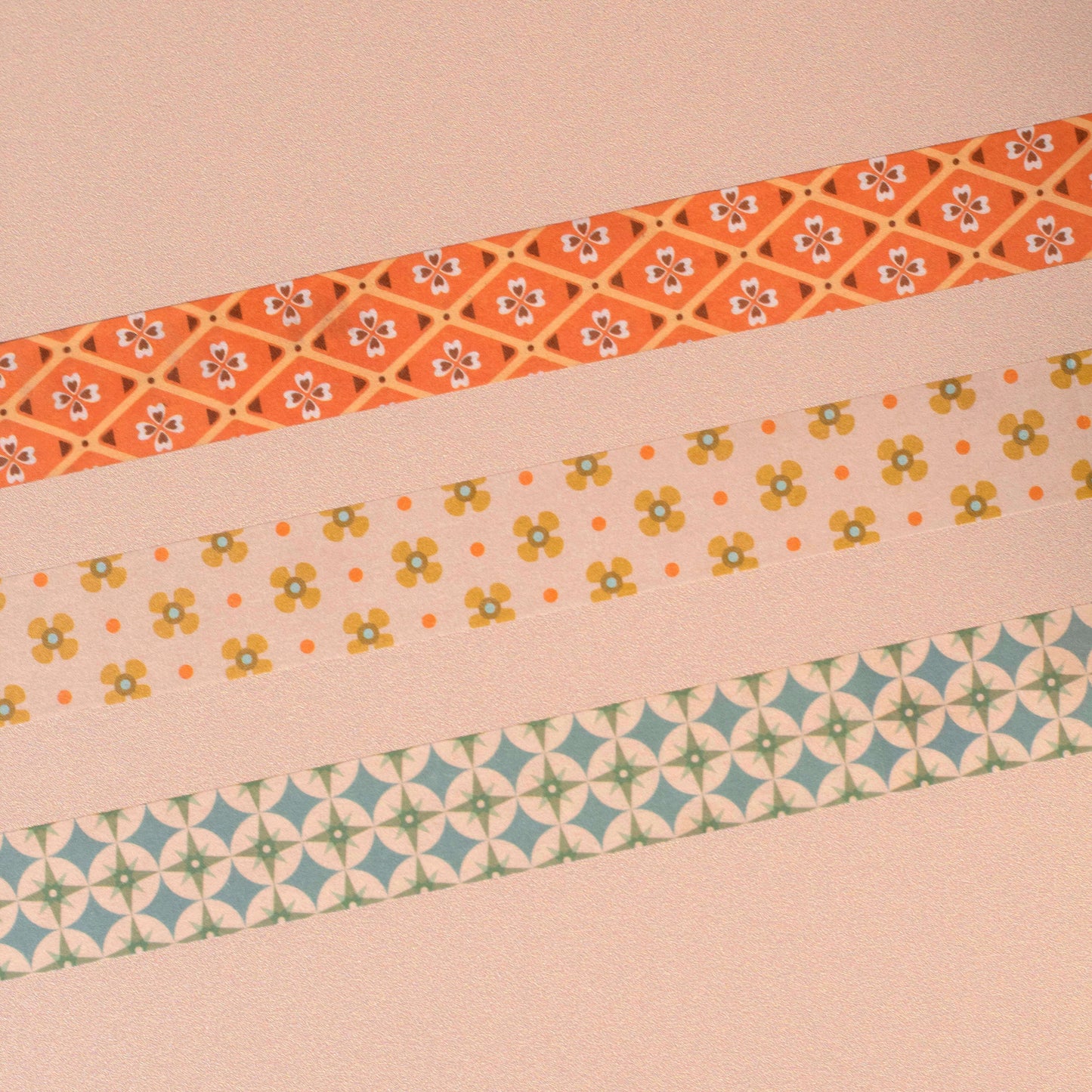 Three decorative tape strips with geometric star and floral patterns on a beige background