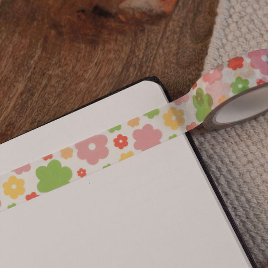 A pink, orange, yellow and green floral washi tape stuck in a notebook.