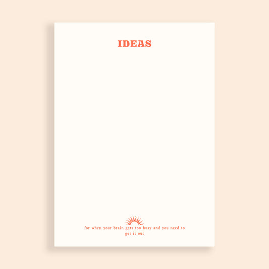 Blank notepad on a beige background. The notepad has red text at the top saying 'IDEAS' and a small line of text at the bottom saying 'for when your brain gets too busy and you need to get it out'