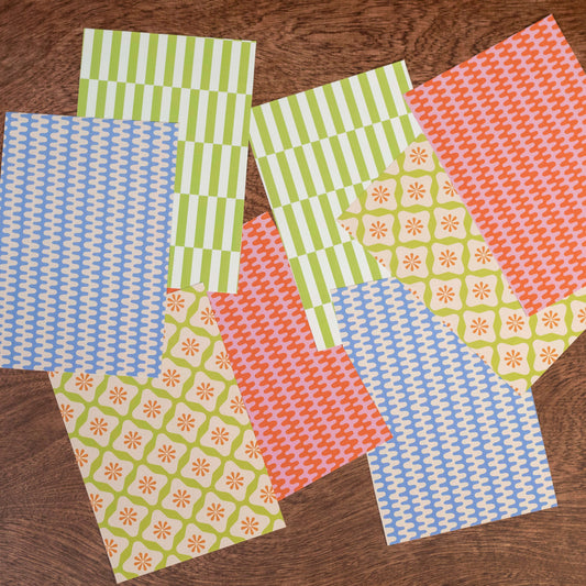 Set of patterned paper sheets on a wooden surface
