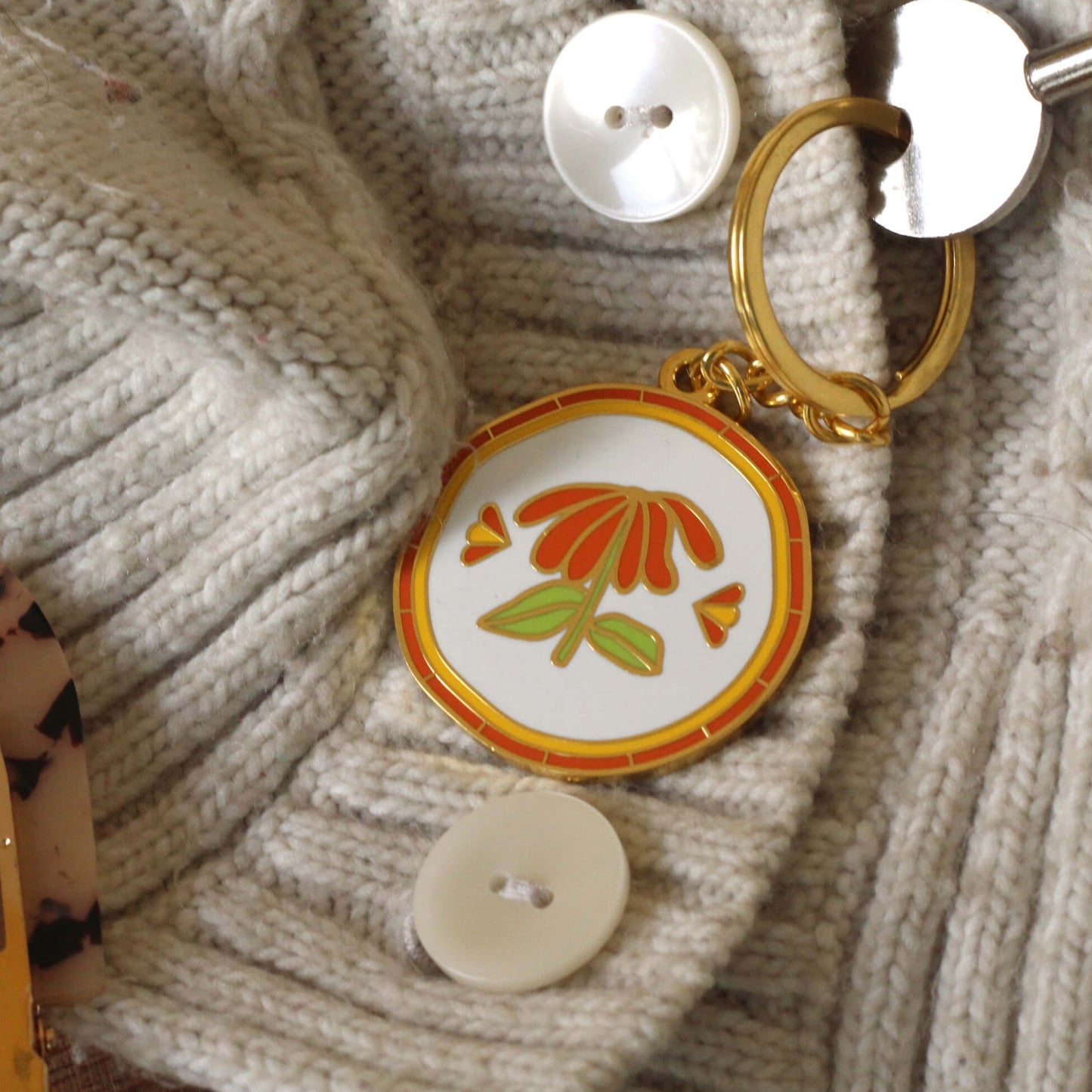 A flower keychain on a woollen fabric.