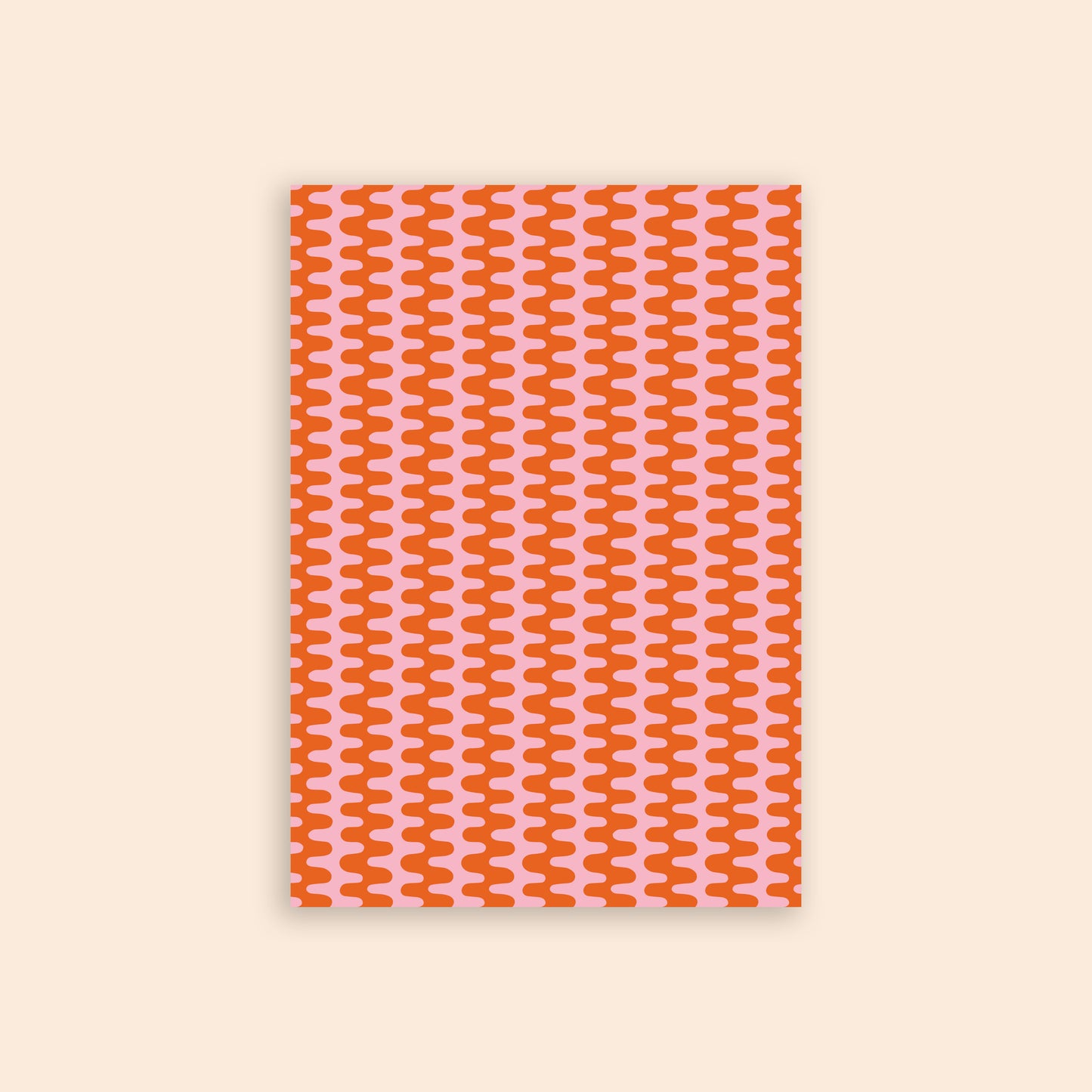 Pink and orange wavy pattern craft paper in front of a beige background.