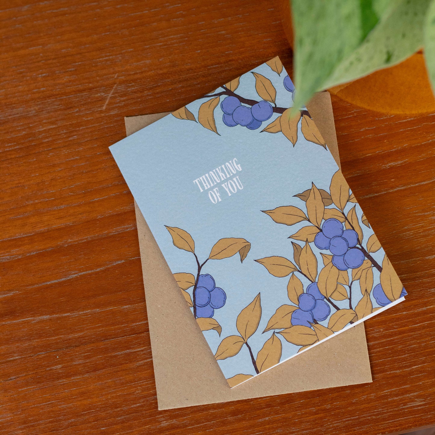Greeting card with a plum tree design on a wooden surface