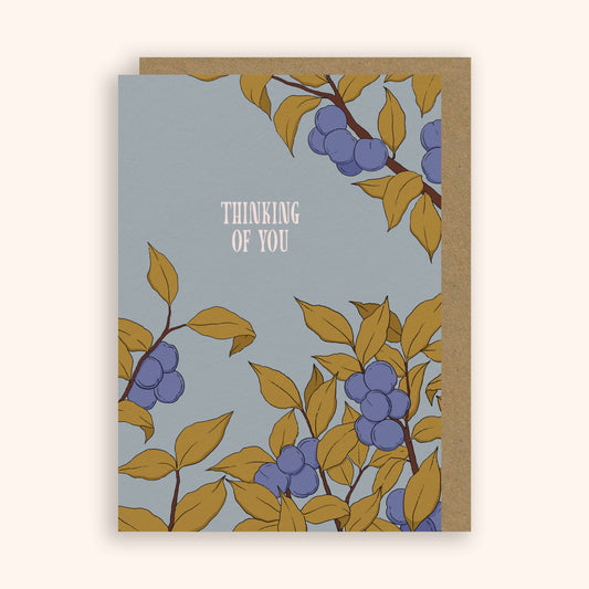 Greeting card with plum tree design on a light blue background, featuring the text 'Thinking of You'.