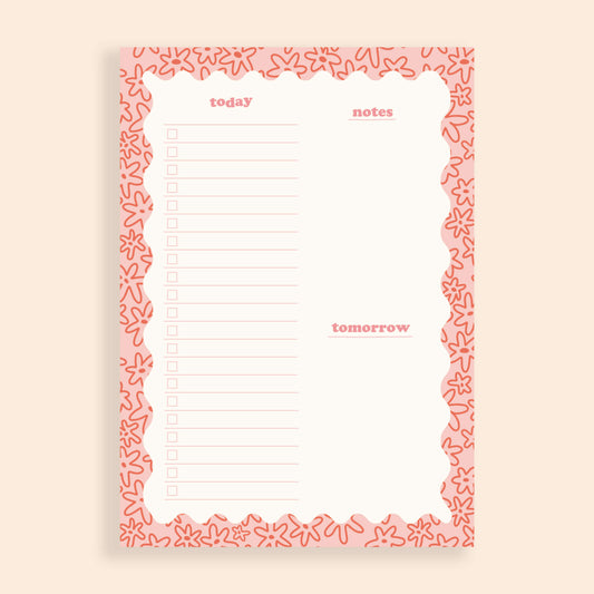 A daily desk planner with a pink wavy border, the border is filled with a doodle floral pattern.