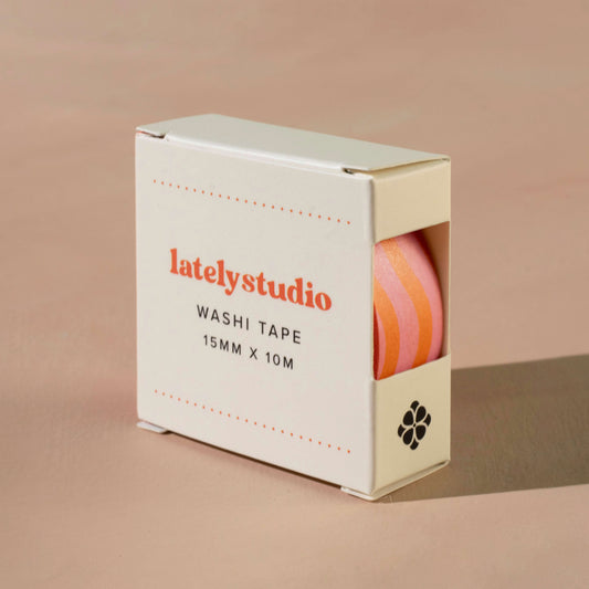 Pink & orange wavy striped washi tape packaged in a branded cardboard box in front of a beige background.